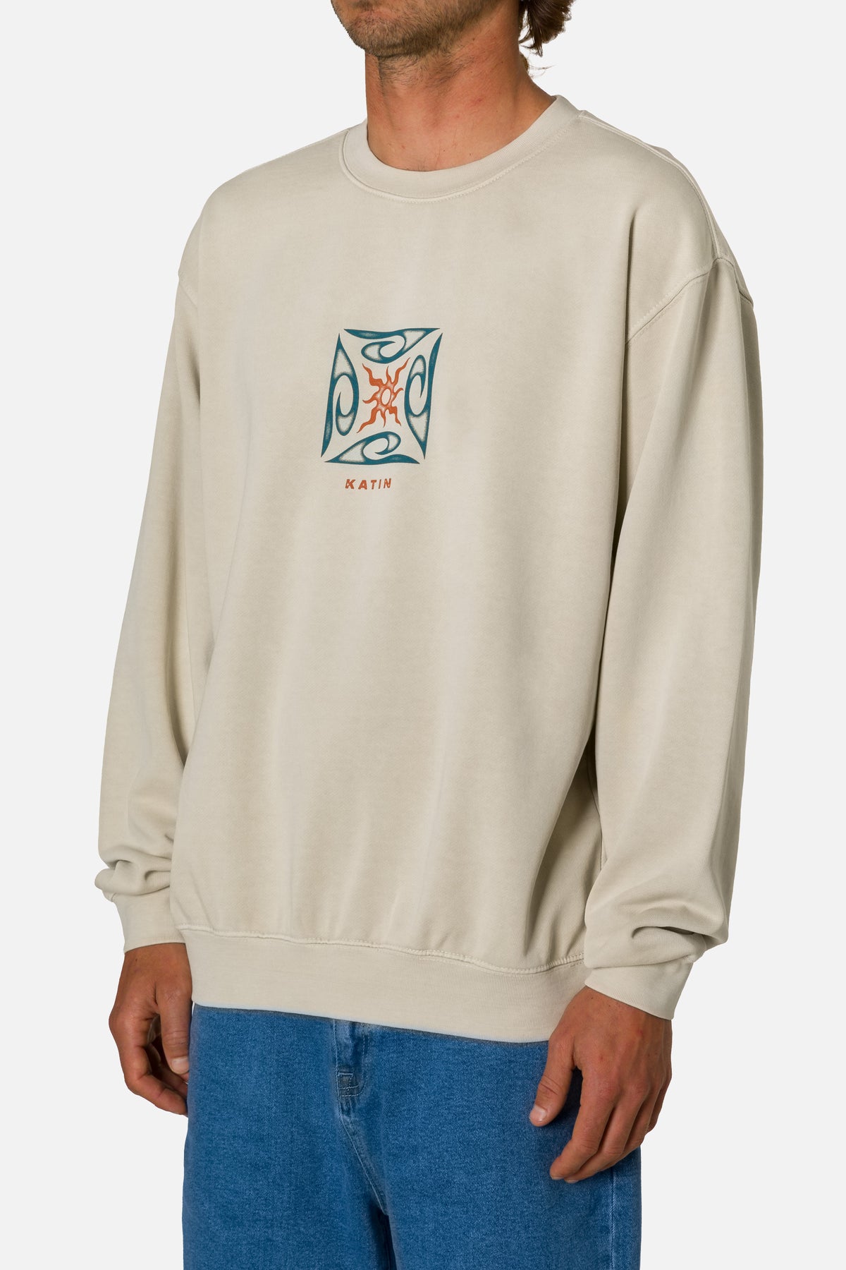 Person wearing a beige sweatshirt with a logo on a white background