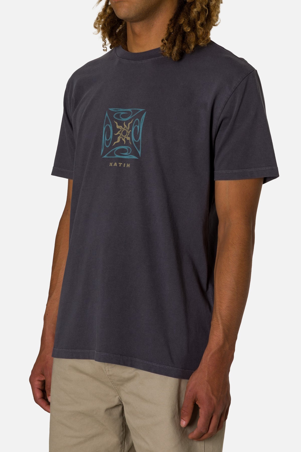 Person wearing a dark gray t-shirt with a logo on a white background
