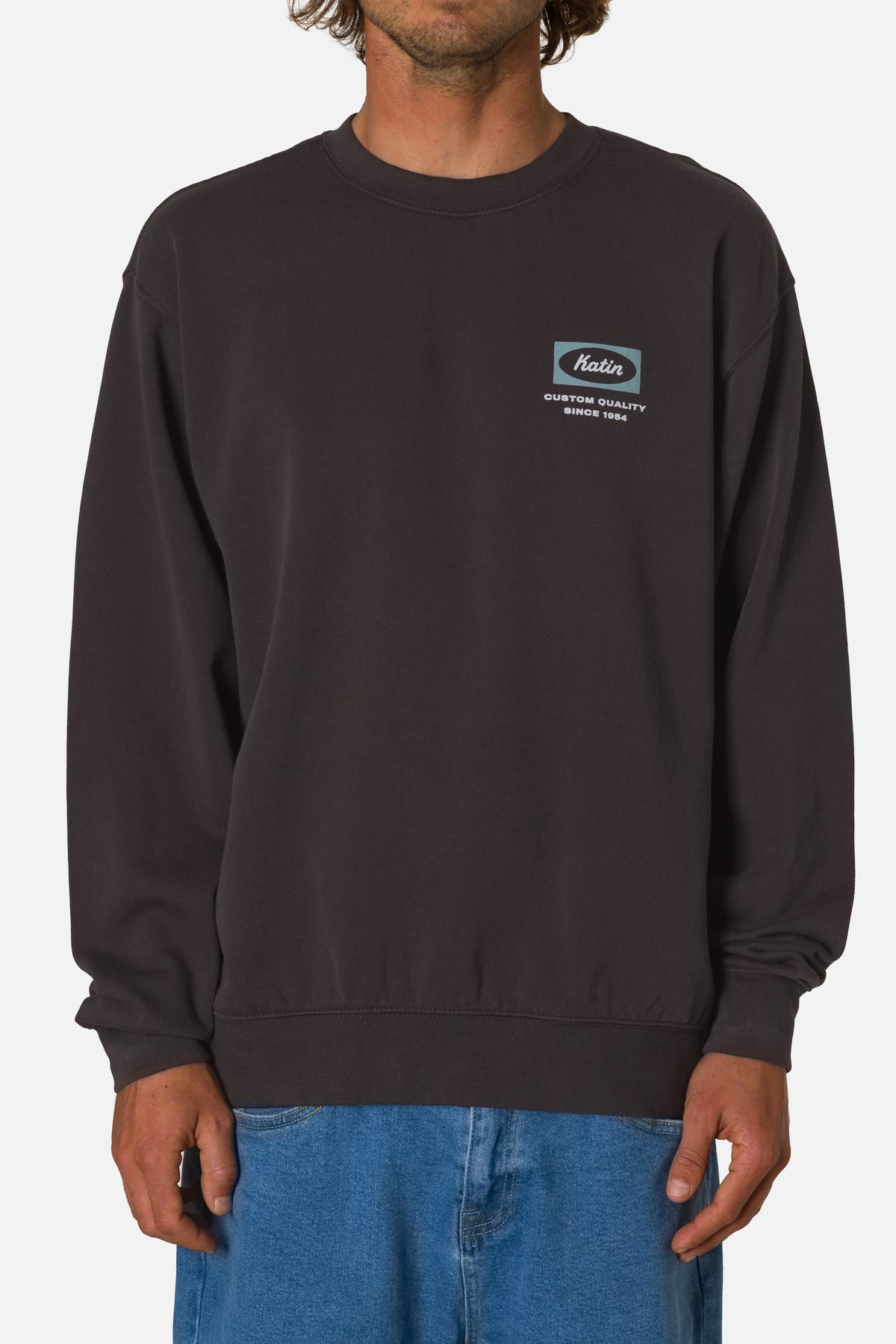 Person wearing a black sweatshirt with a logo on a white background