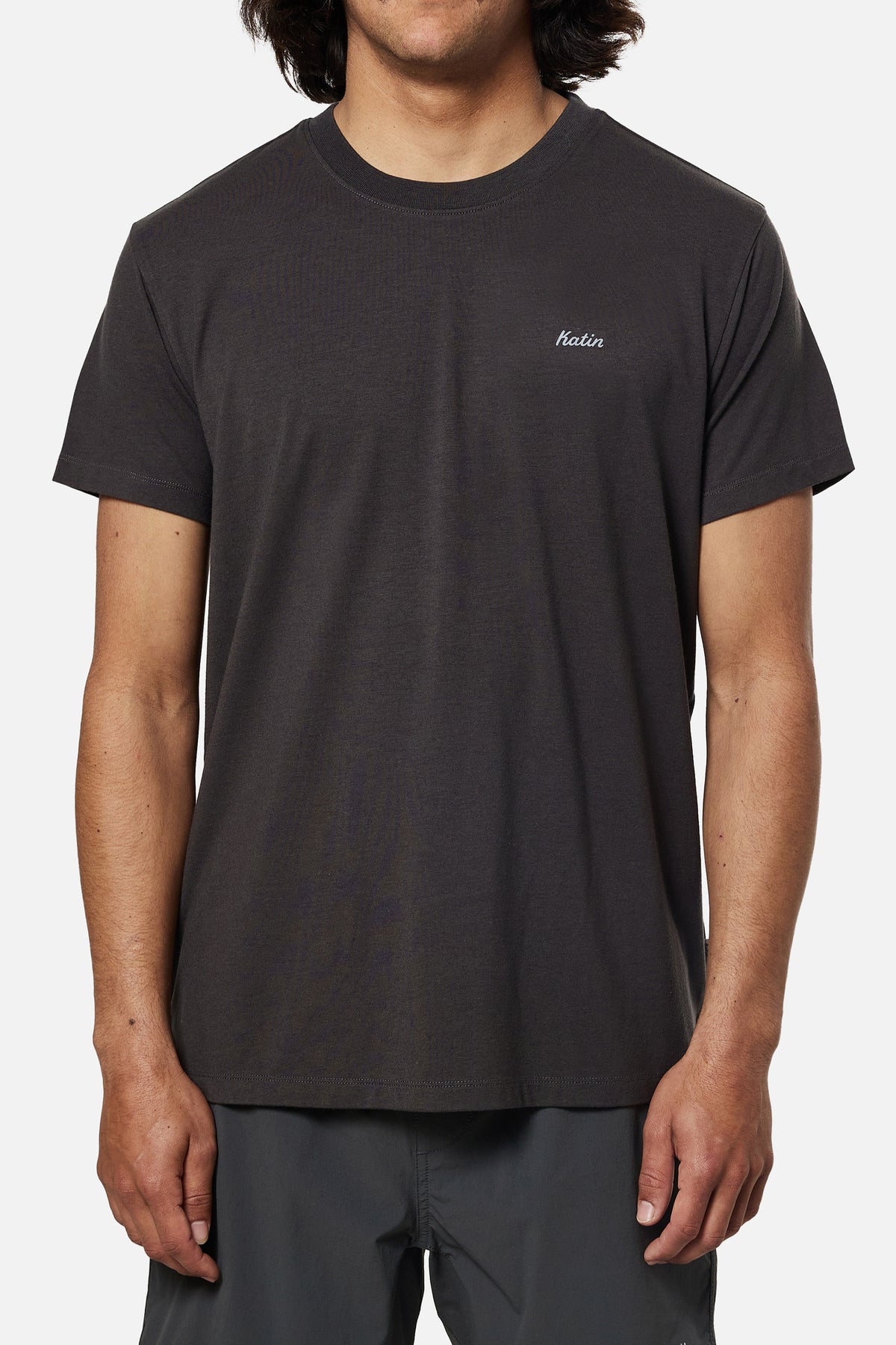 Person wearing a black t-shirt with a brand logo on a white background