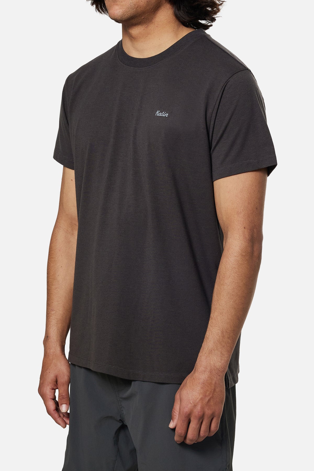 Person wearing a black t-shirt with a brand logo on a white background