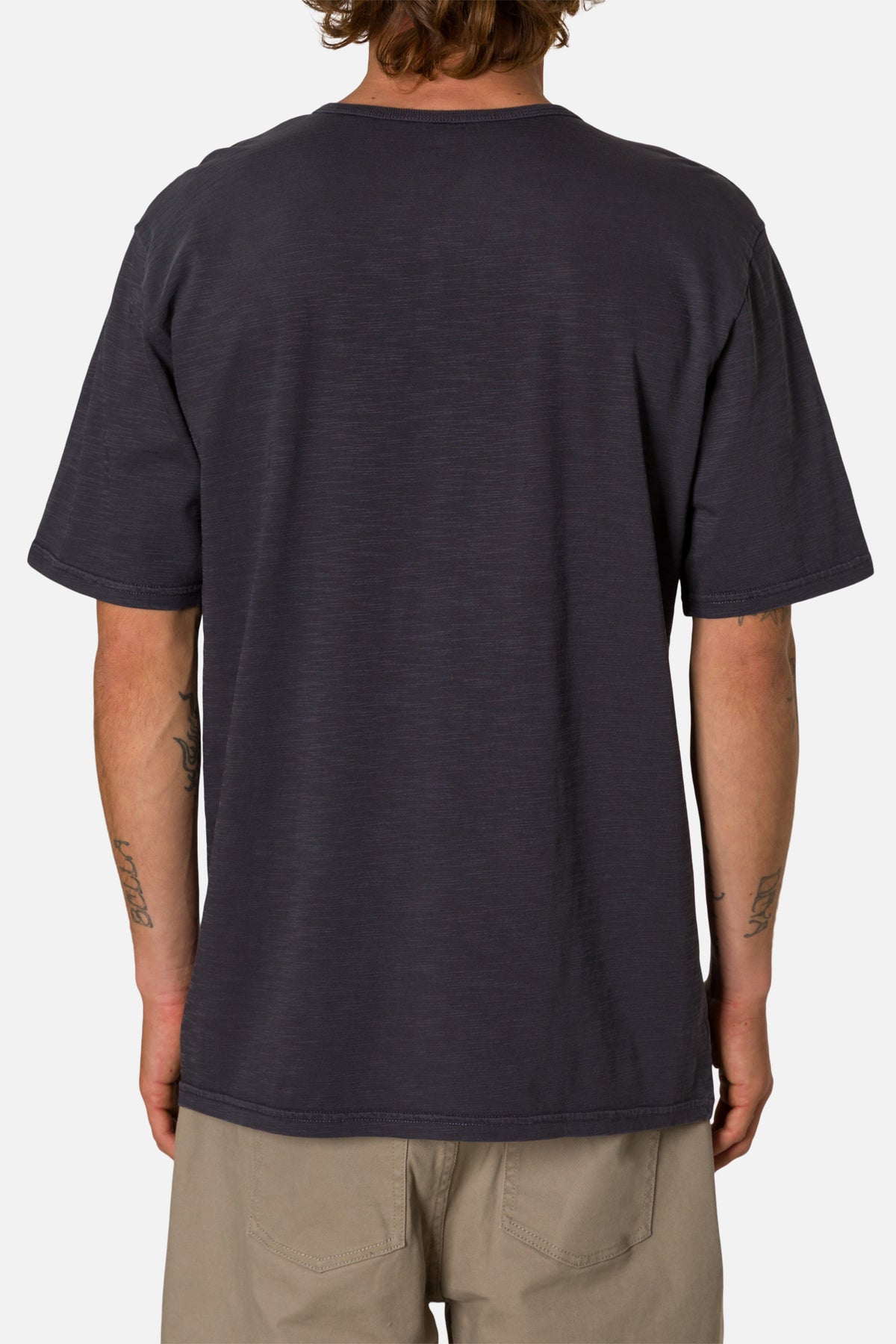 Man wearing a navy henley shirt on a white background