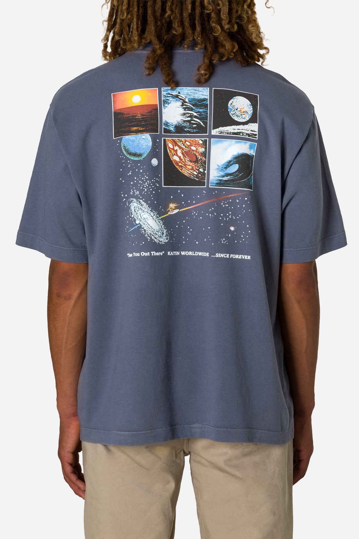 Person wearing a blue t-shirt with space-themed graphics on the back