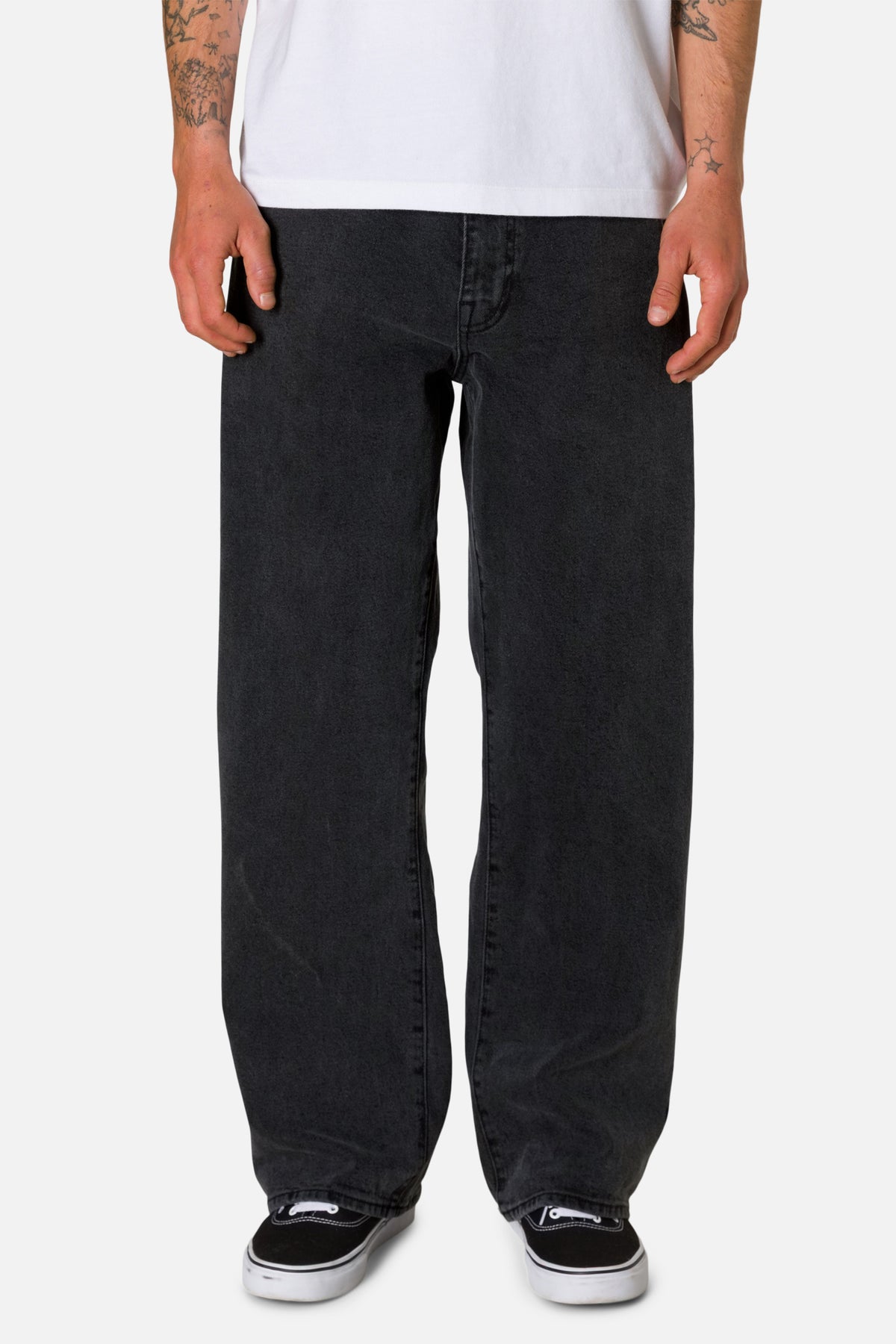 Black washed jeans worn by a person on a white background