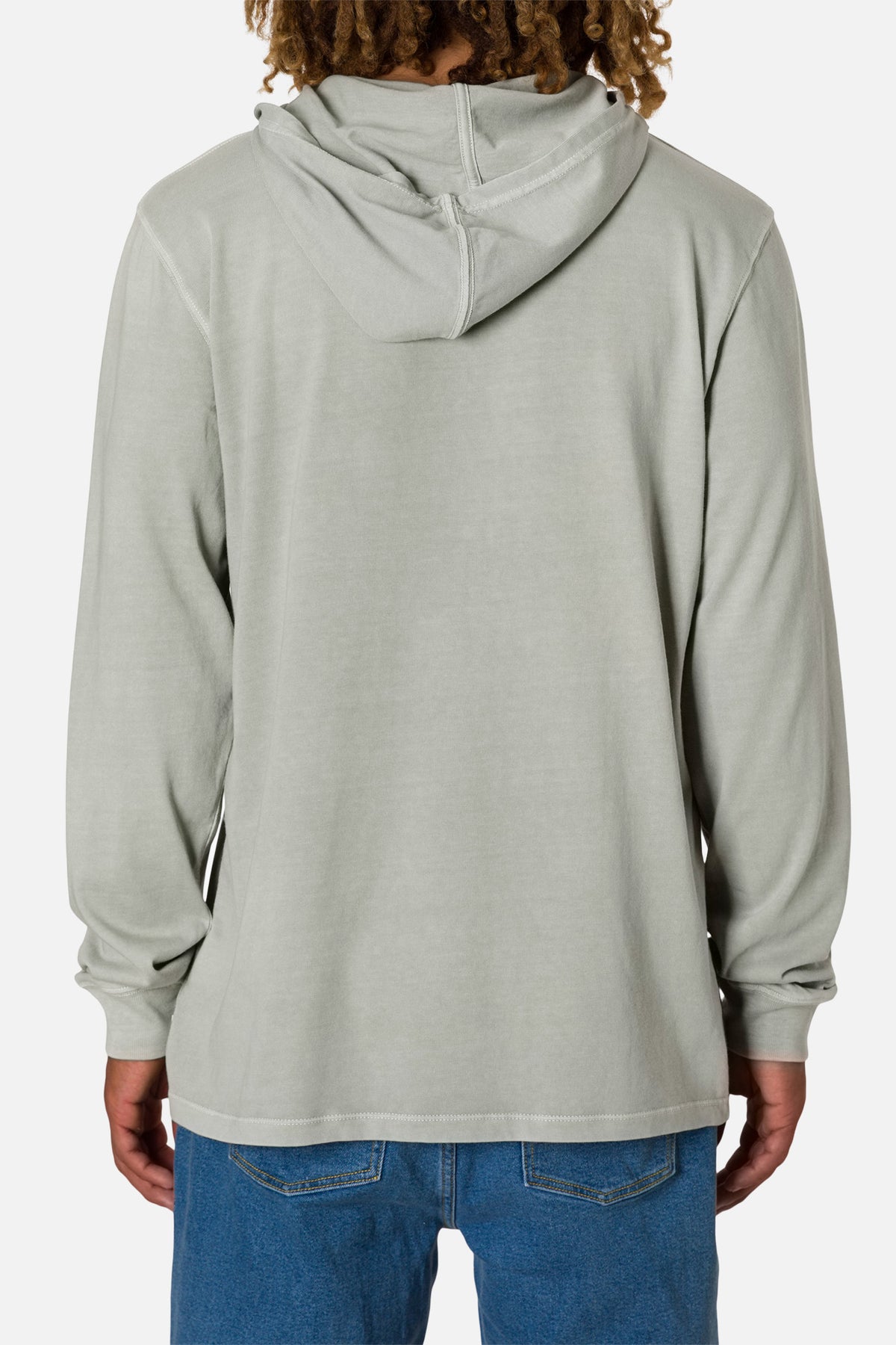 Back of person wearing a off white hoodie and blue jeans on a white