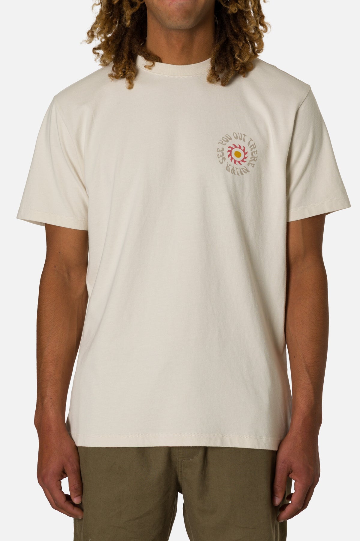 Person wearing a beige t-shirt with a colorful logo on a white background