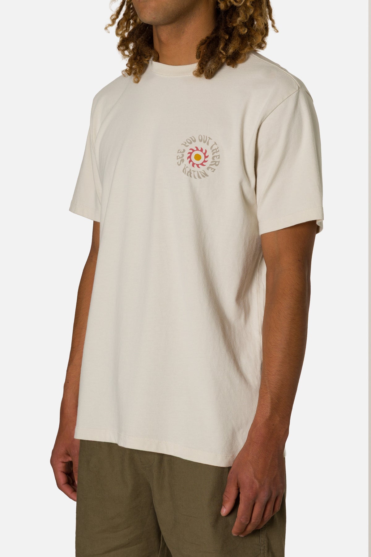 Person wearing a white t-shirt with a colorful graphic on a plain background