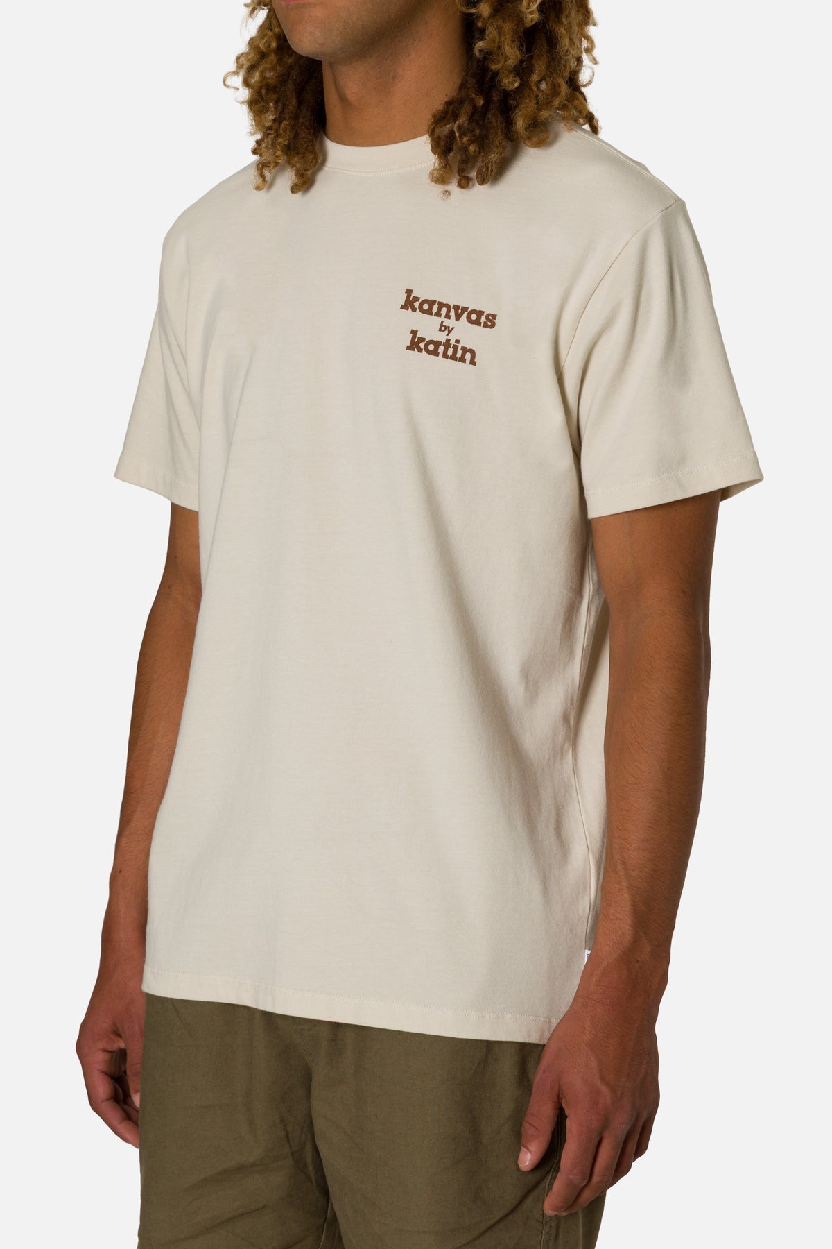 Person wearing a beige t-shirt with 'kanvas by katin' logo on a plain background