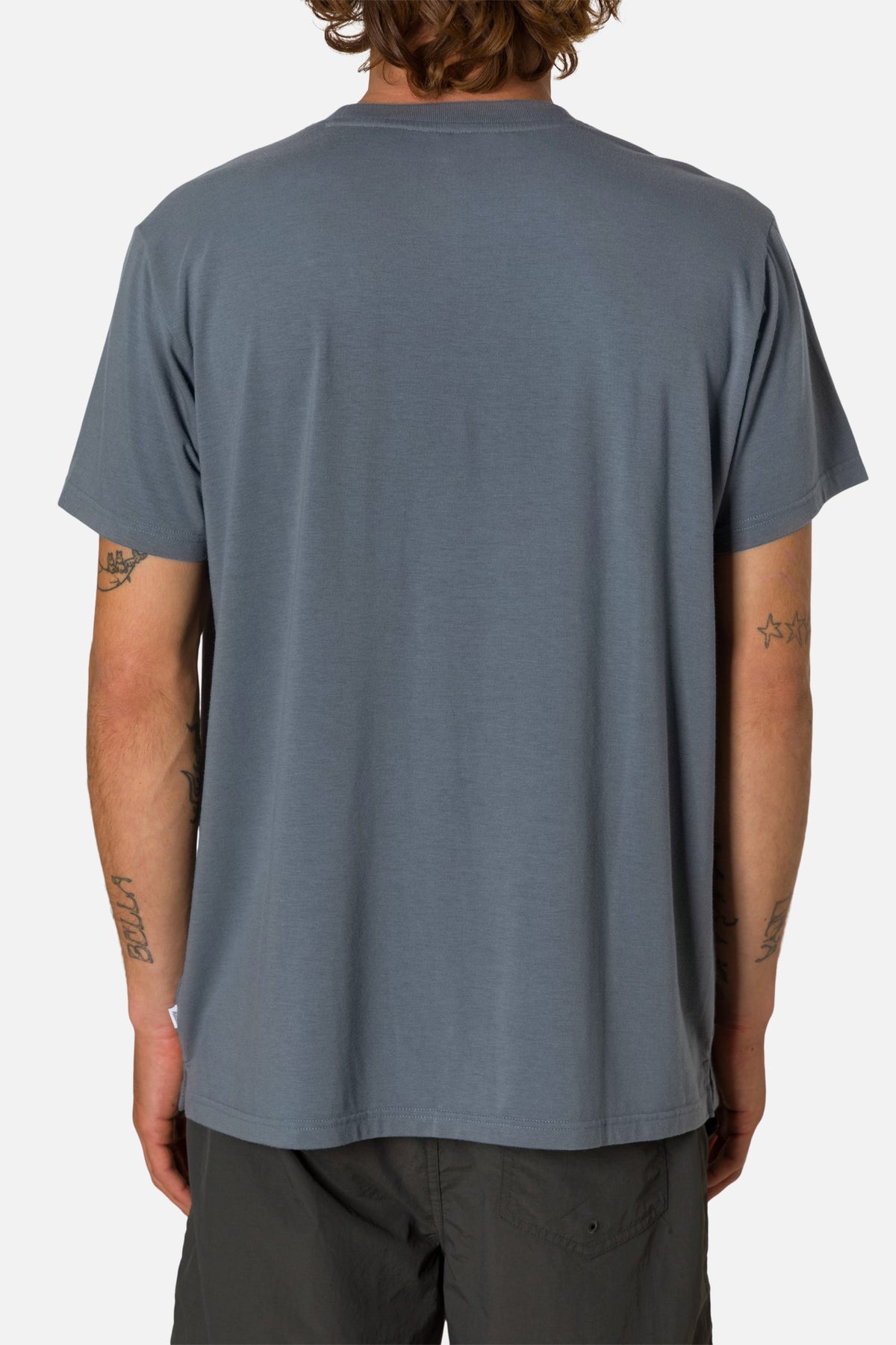 Person wearing a plain blue t-shirt on a white background