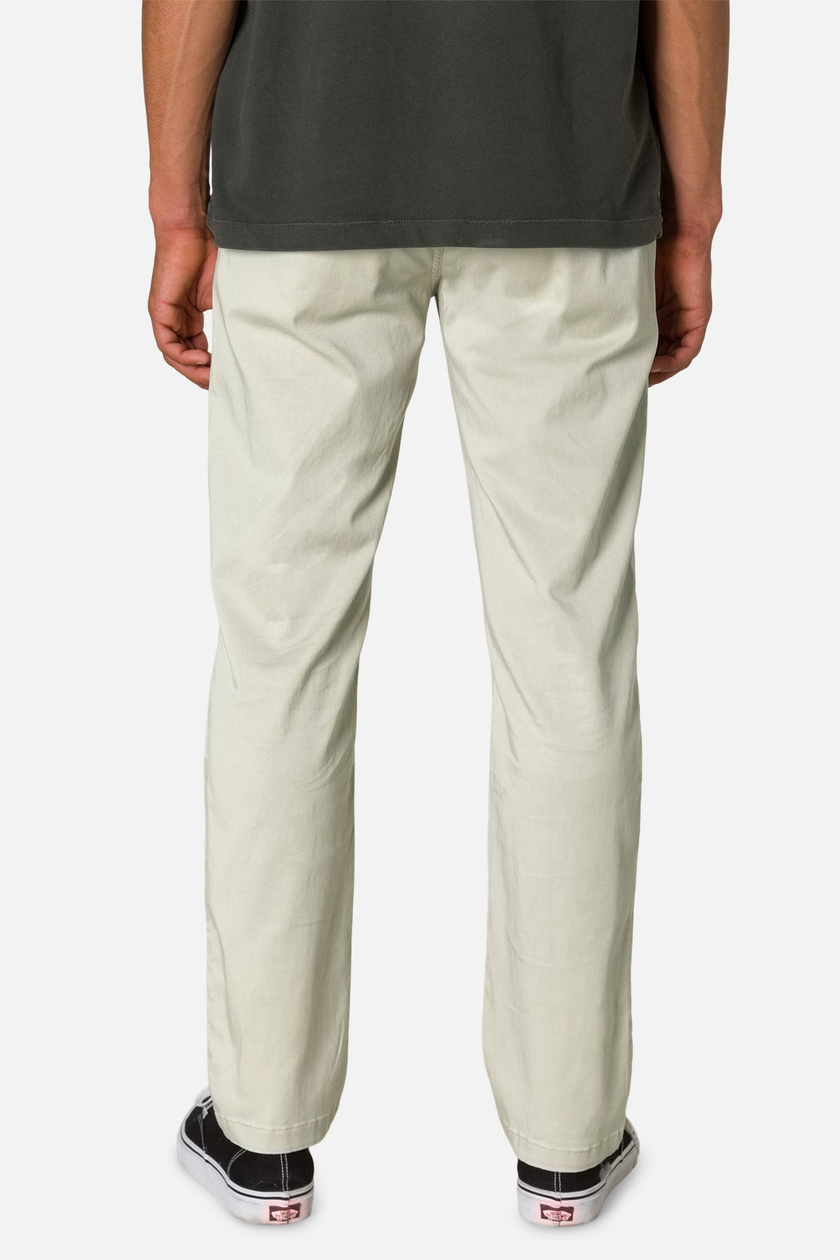 Person wearing light-colored pants and black shoes on a white background