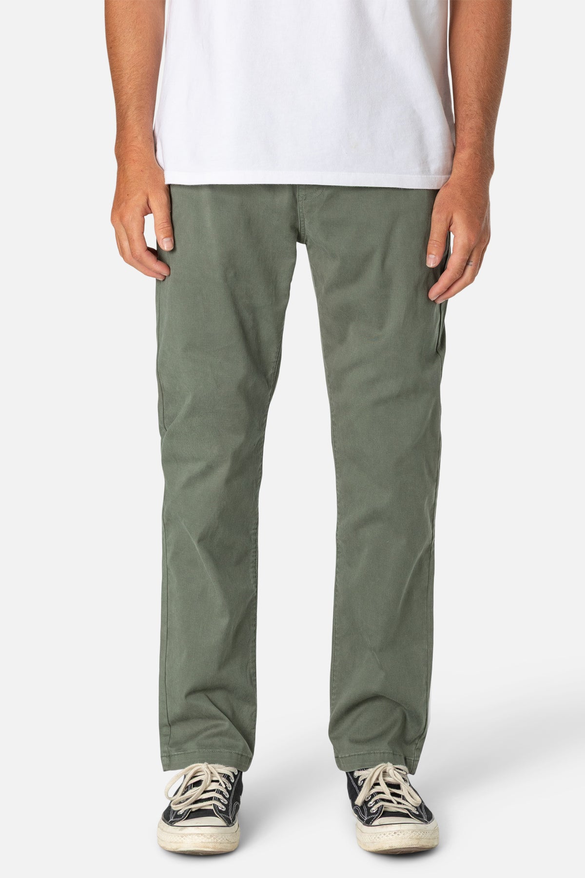 Person wearing green pants and a white shirt on a white background