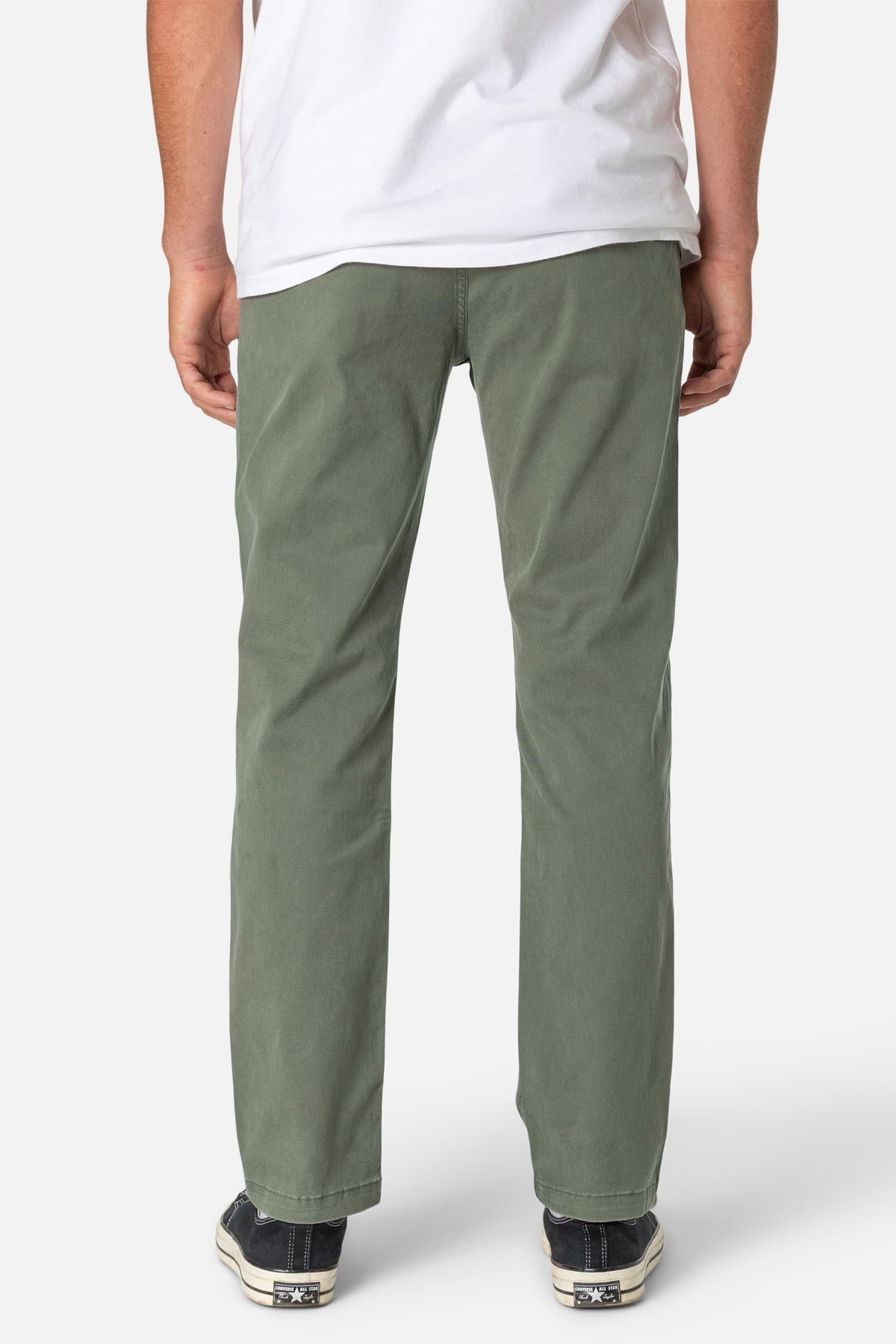 Person wearing green pants and a white shirt on a white background
