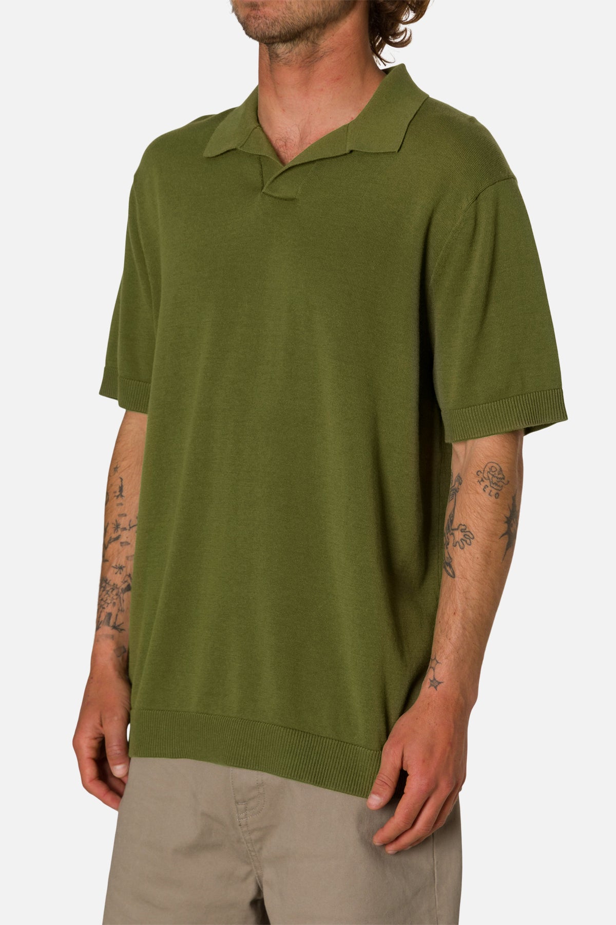 Person wearing a green polo shirt on a white background