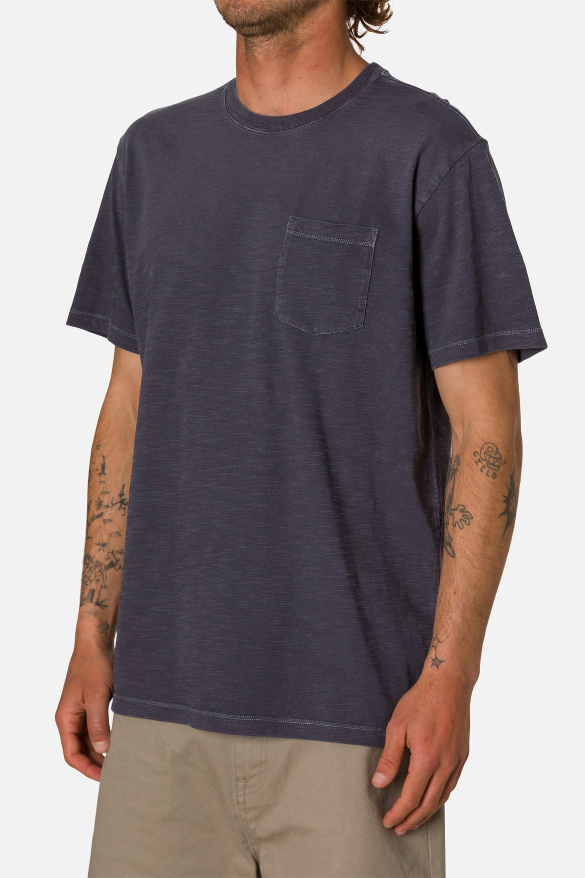 Man wearing a dark blue t-shirt with a pocket on a white background