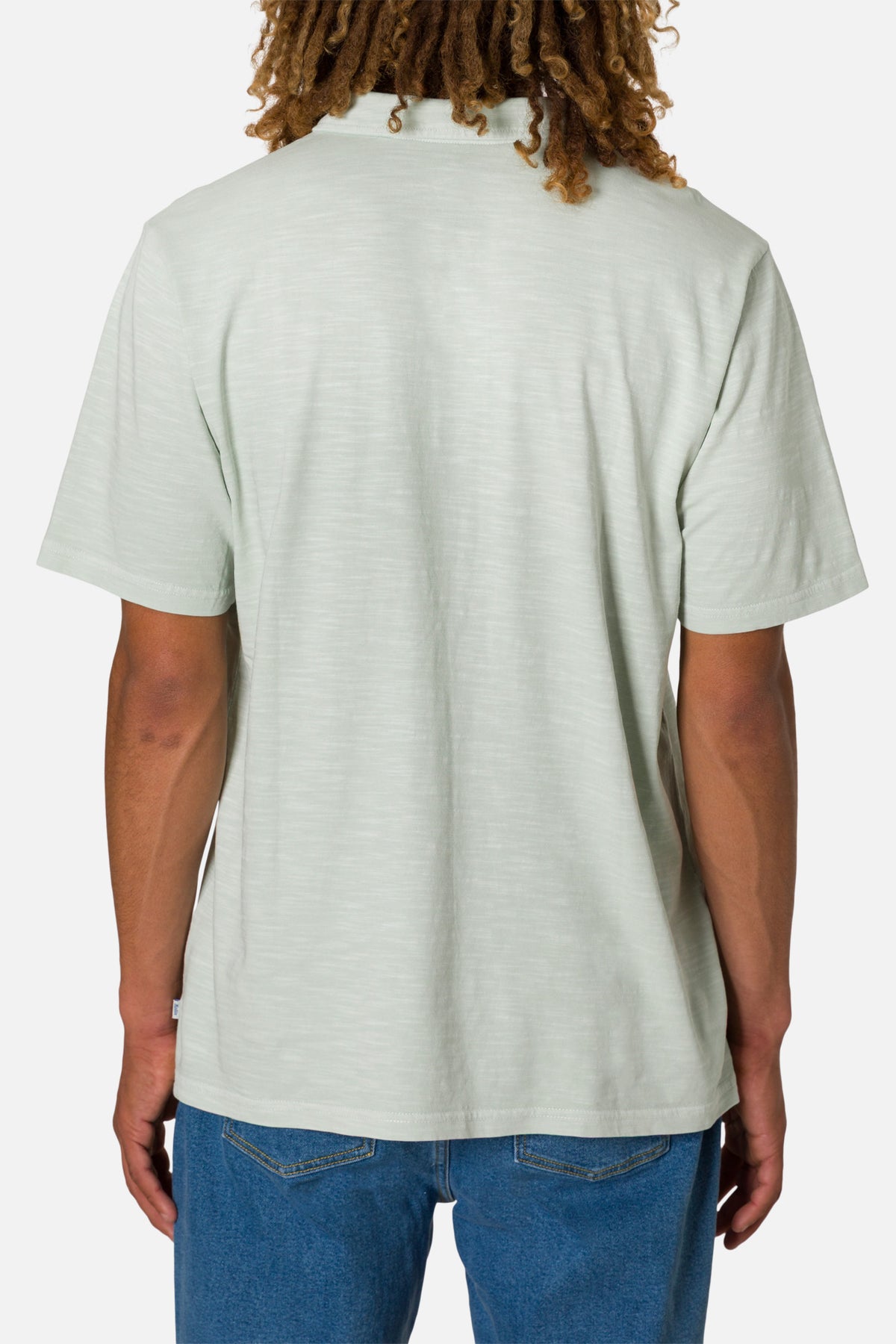 Person wearing a light gray t-shirt and blue jeans on a white background