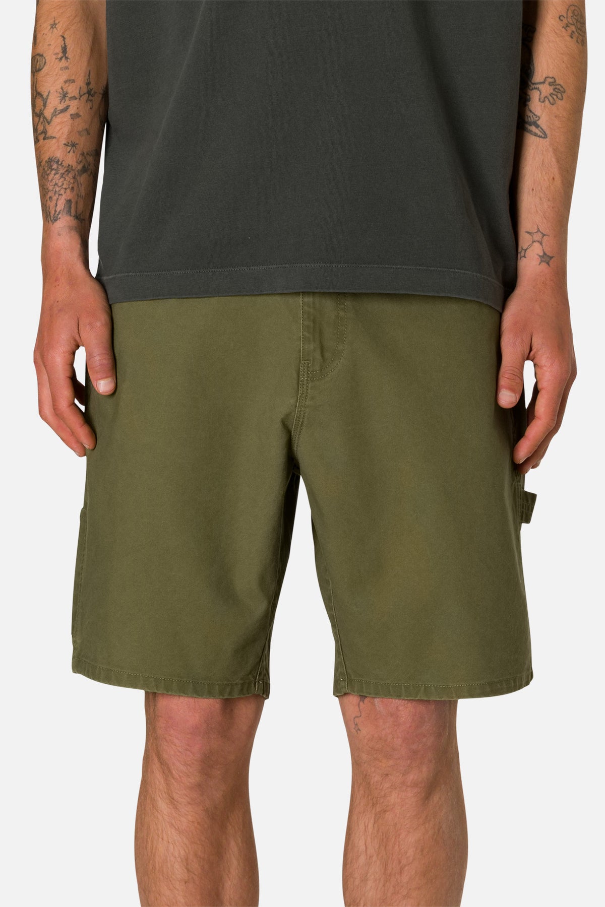 Front view person wearing Olive shorts and a black shirt on a plain background