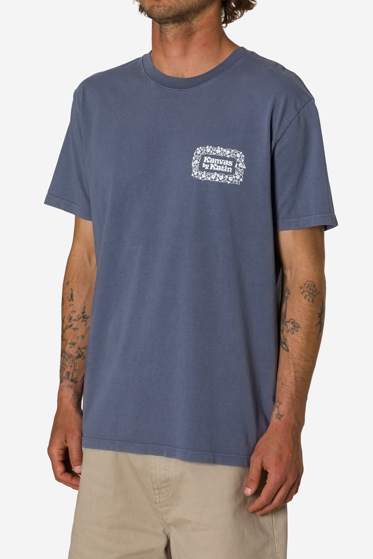 Man wearing a blue t-shirt with a logo on a white background