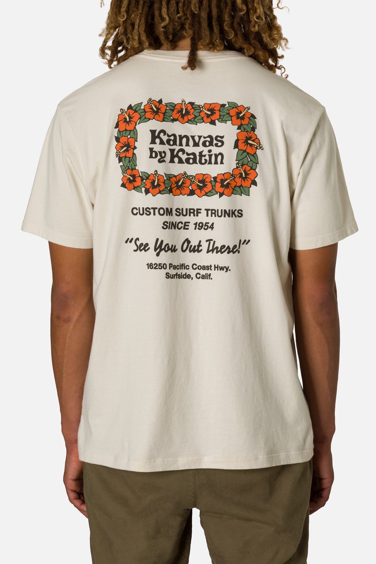 Person wearing a beige t-shirt with a colorful graphic and text on the back.