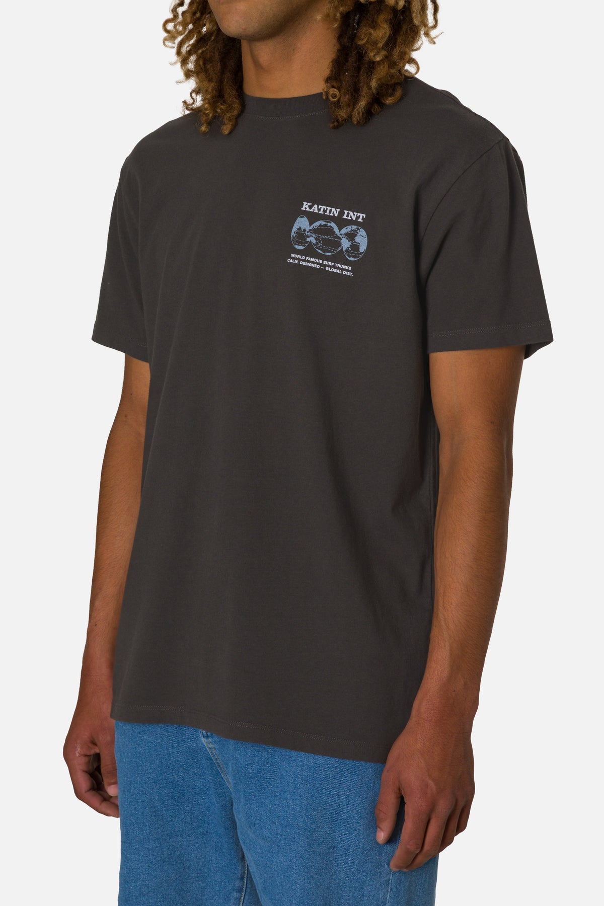 Person wearing a dark gray t-shirt with a graphic design on a plain background