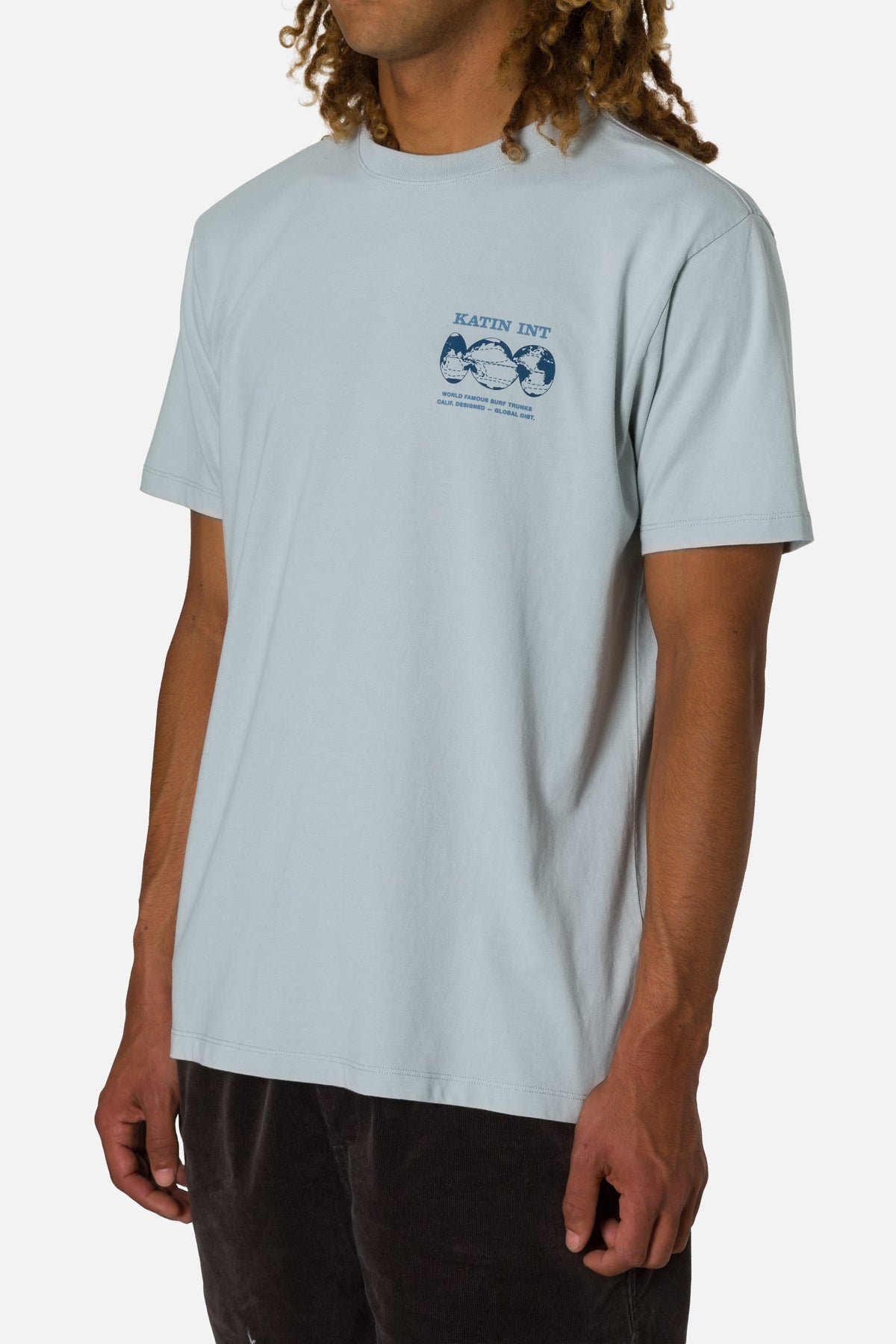 Person wearing a light blue t-shirt with a graphic design on a white background