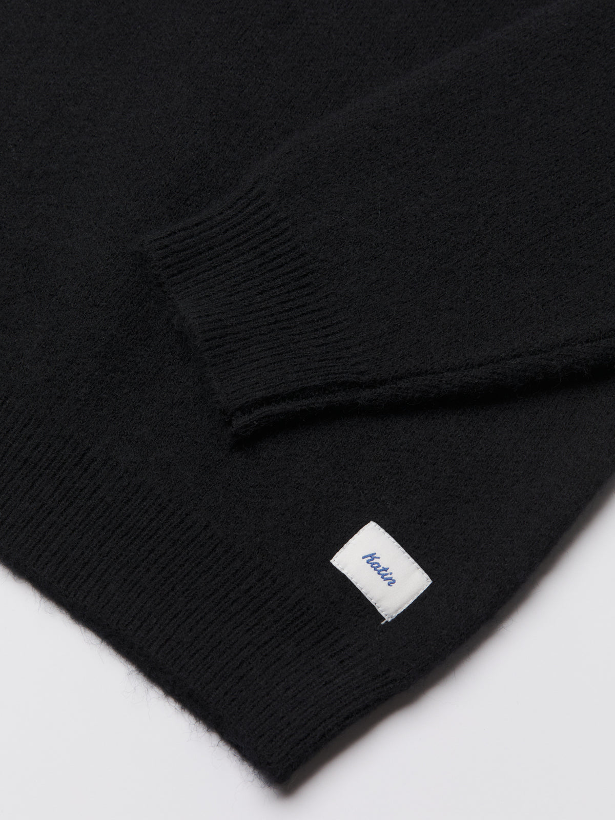 Katin Rivers Sweater in Black, flat, sleeve and flag detail #color_black