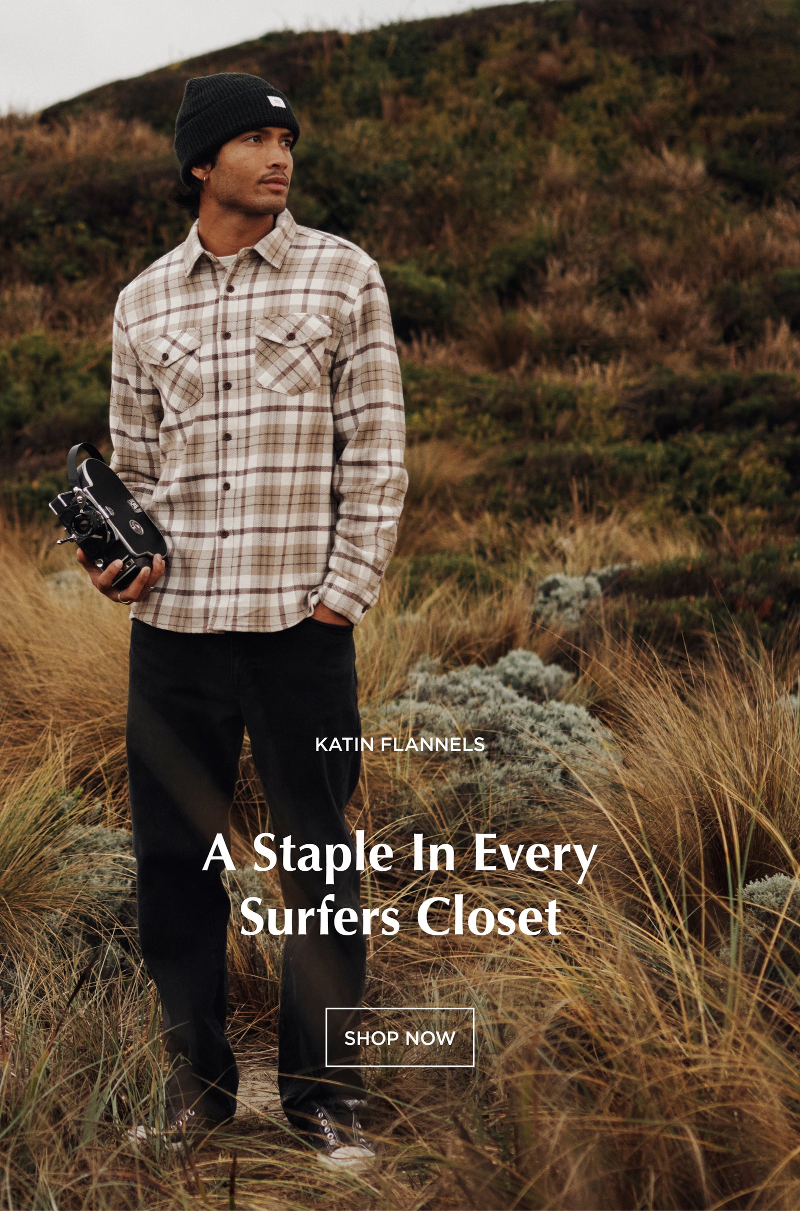 surfer standing on coast line in flannel holding a camera - shop katin flannels, a staple in every surfers closet