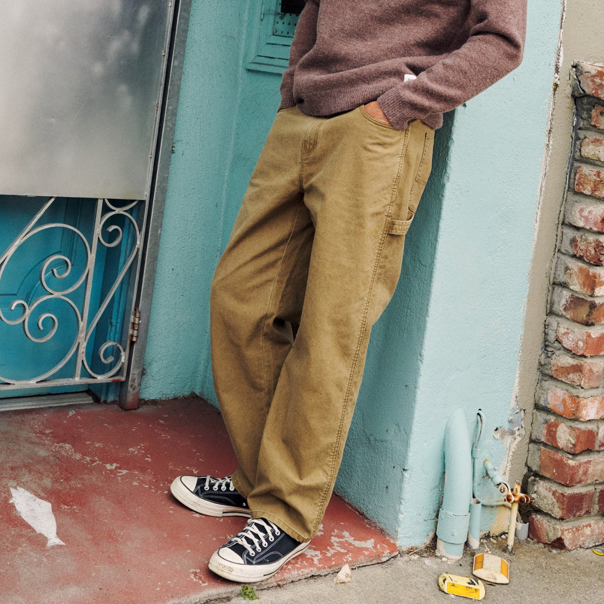 Man leaning on wall wearing Katin pants