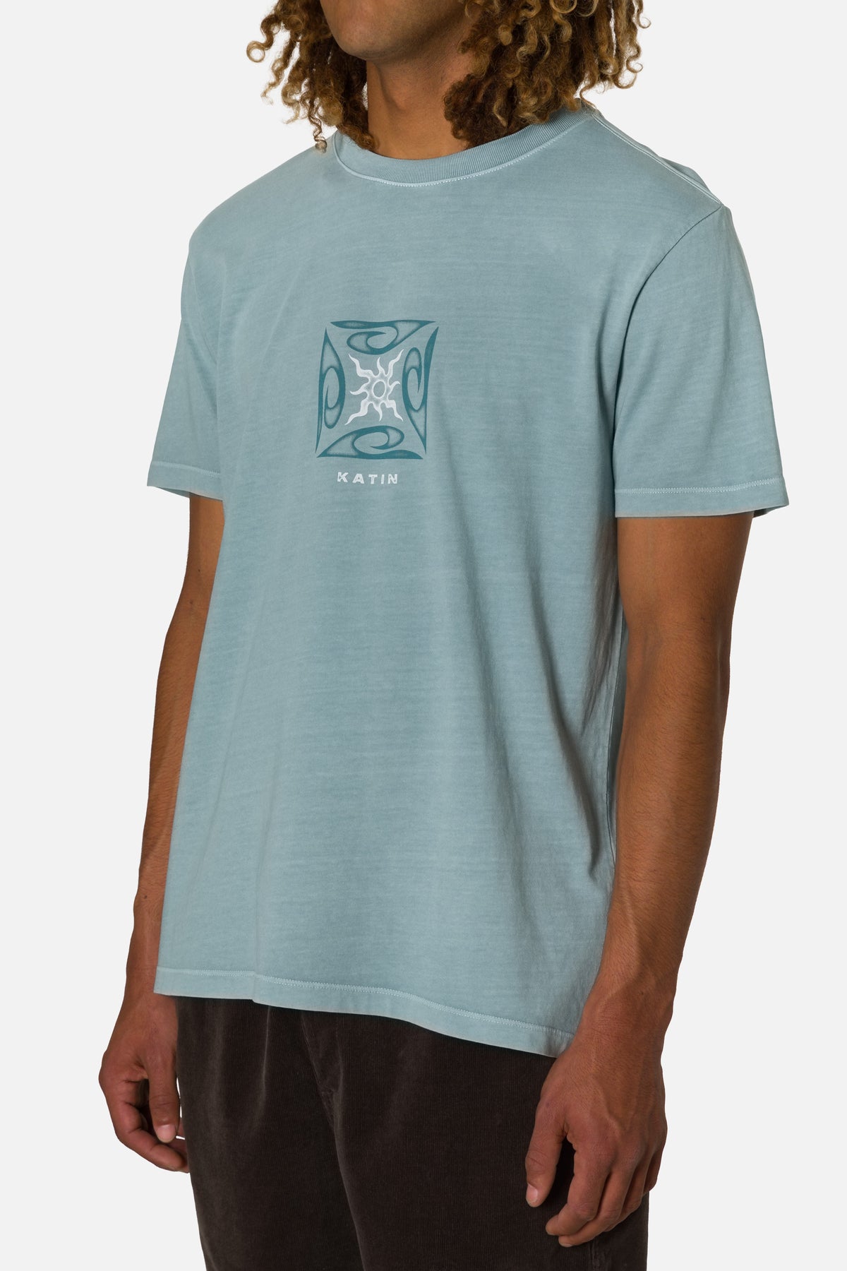Person wearing a light blue t-shirt with a graphic design on a white background