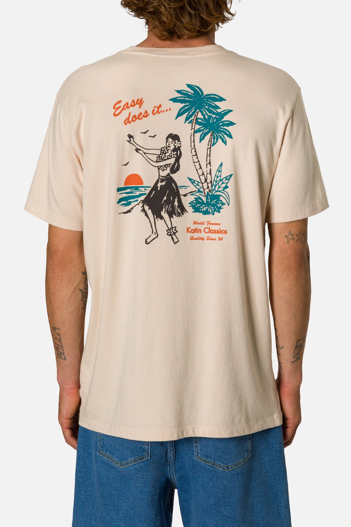 Beige t-shirt with a tropical graphic design on a plain background