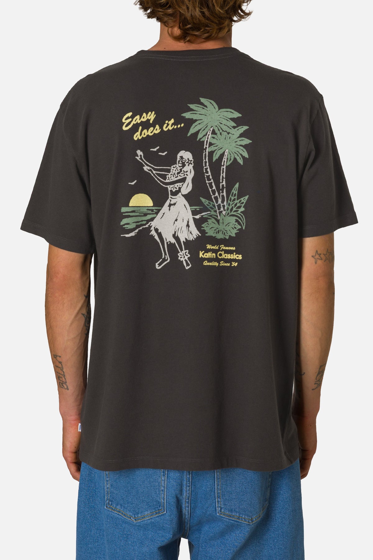 Person wearing a black t-shirt with a hula dancer graphic on the back