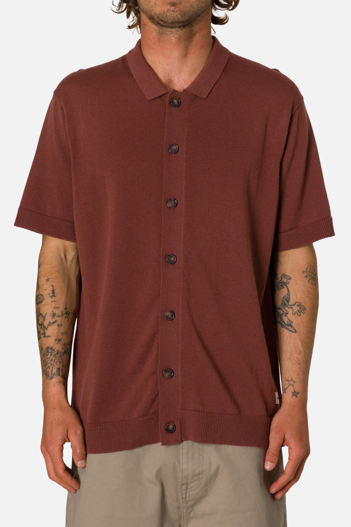 Man wearing a mahogany button-up shirt on a white background