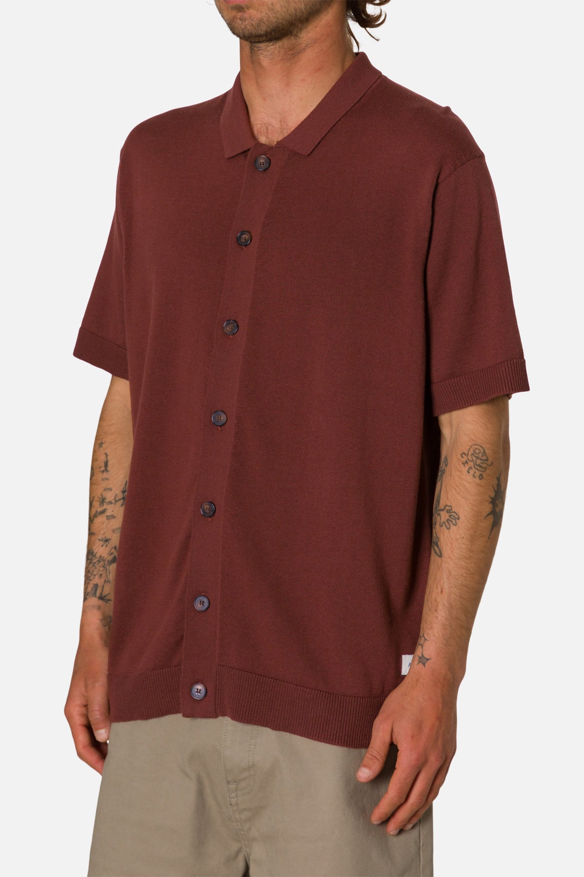 Man wearing a mahogany button-up shirt on a white background