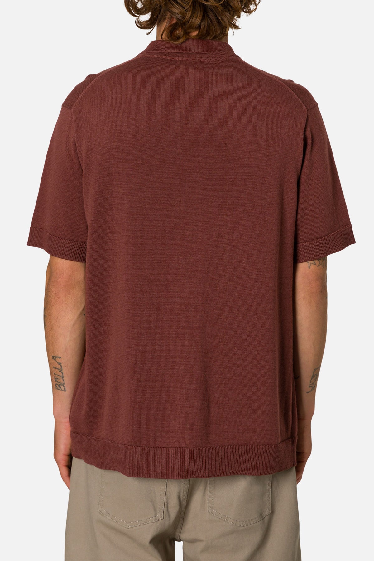 Man wearing a mahogany button-up shirt on a white background