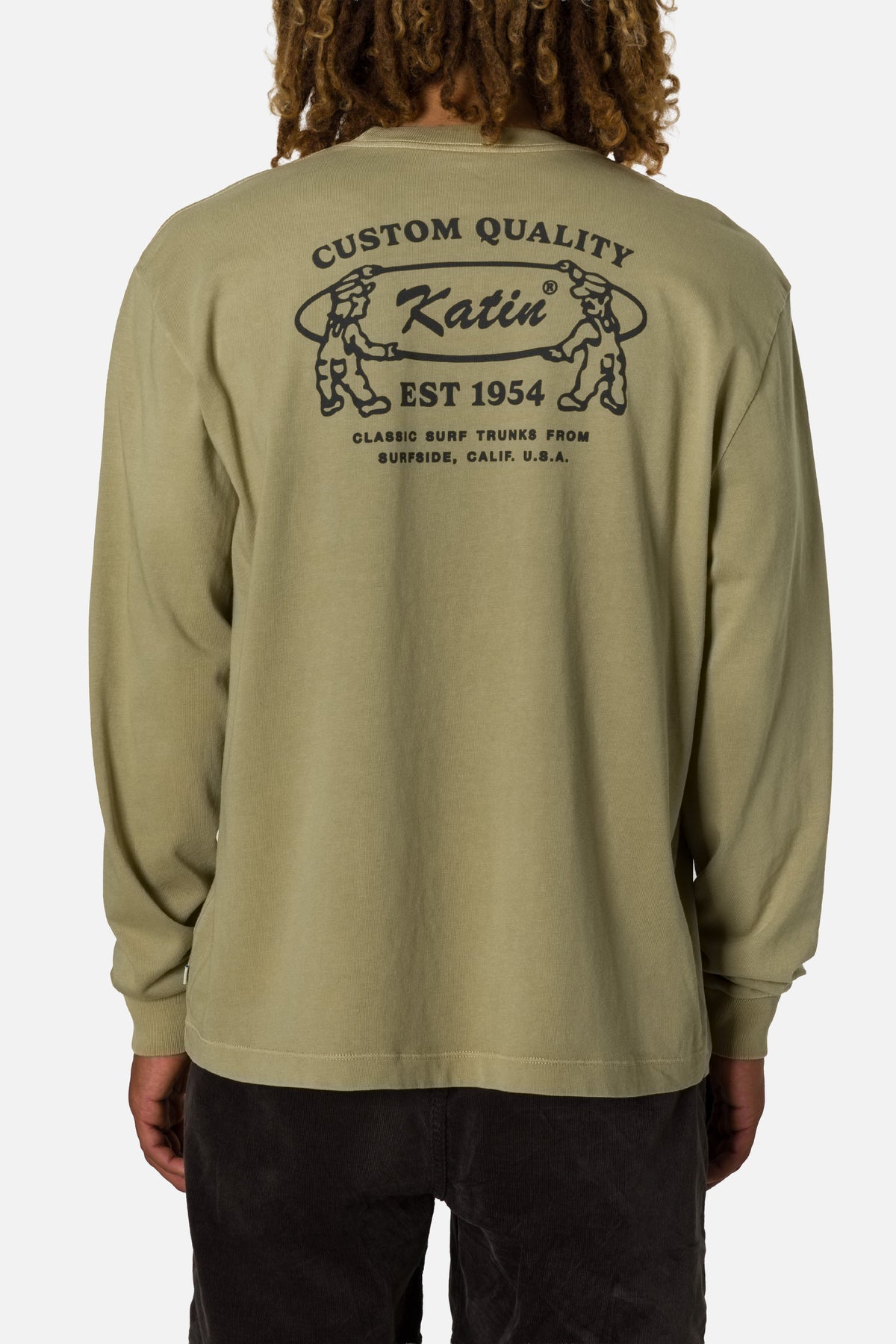 Person wearing a green long-sleeve shirt with Katin branding on the back.