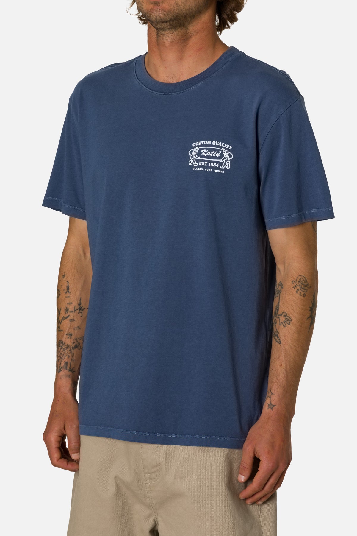 Man wearing a navy blue t-shirt with a logo on a white background