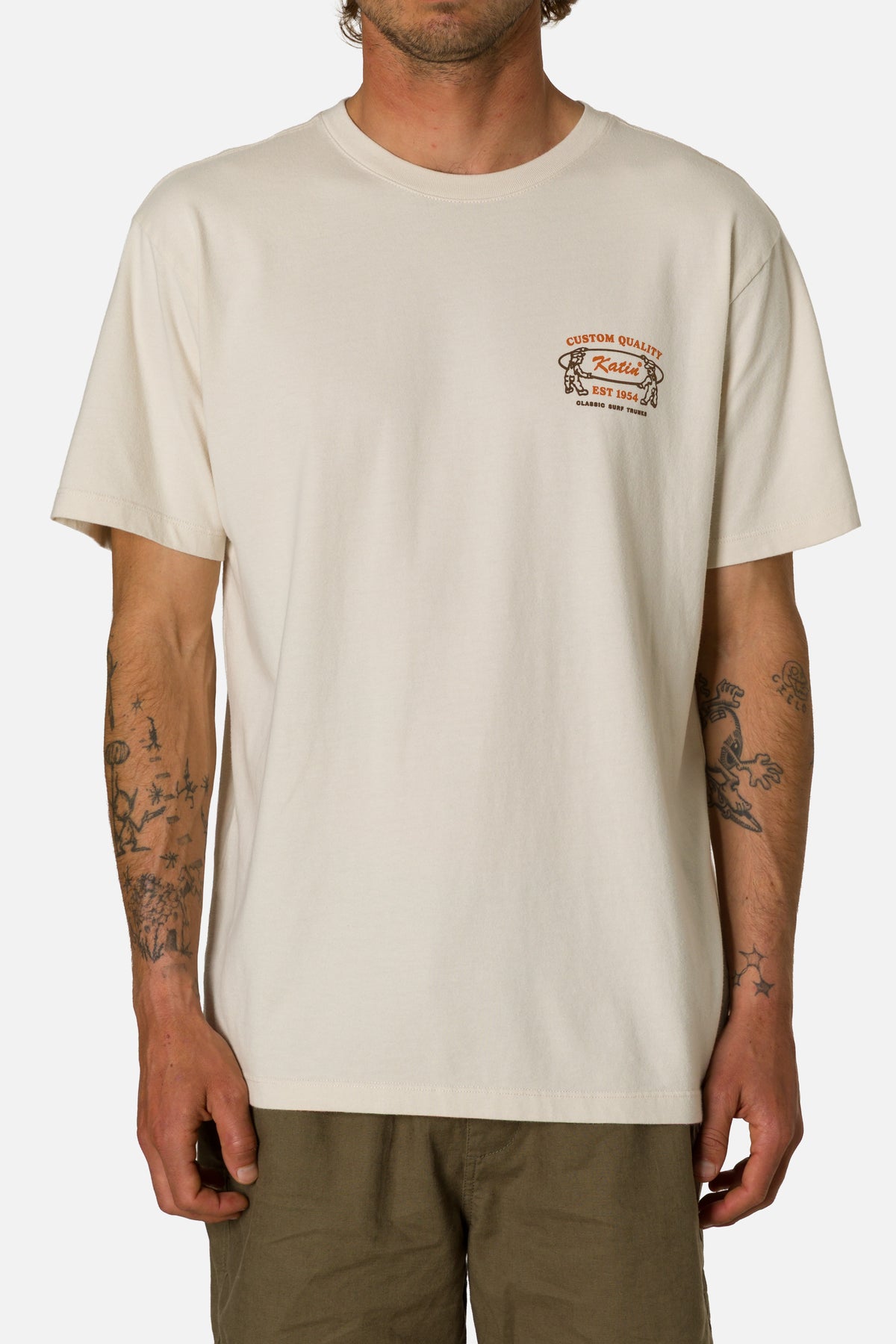 Person wearing a beige t-shirt with a graphic design on a white background