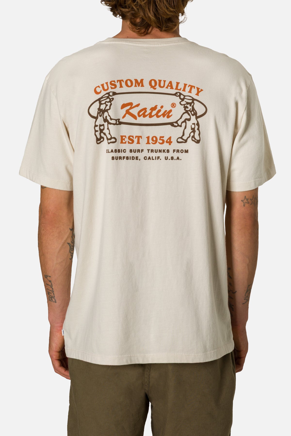 Person wearing a beige t-shirt with Katin branding on a white background