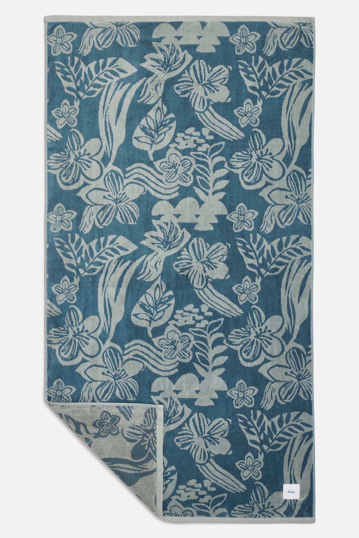 Blue towel with white floral pattern on a white background