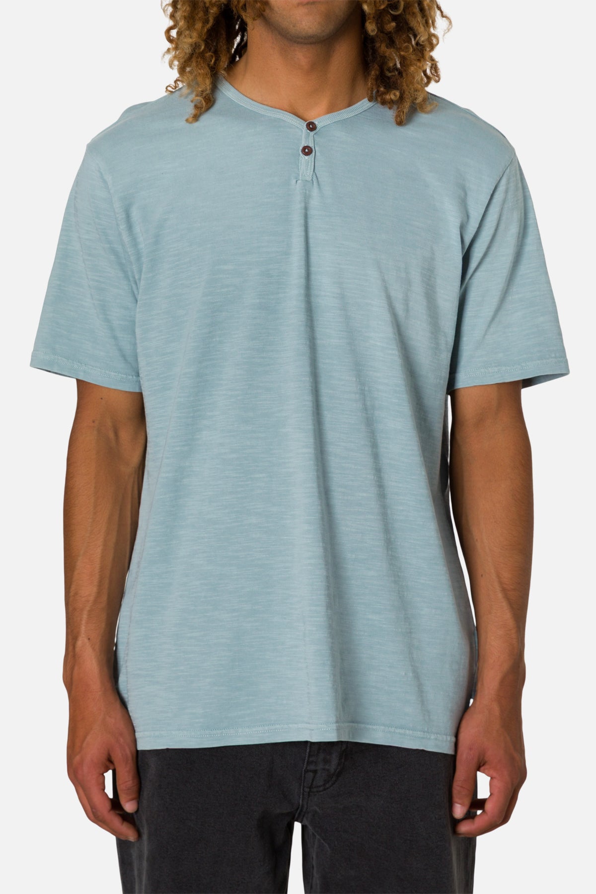 Man wearing a light blue henley shirt on a white background