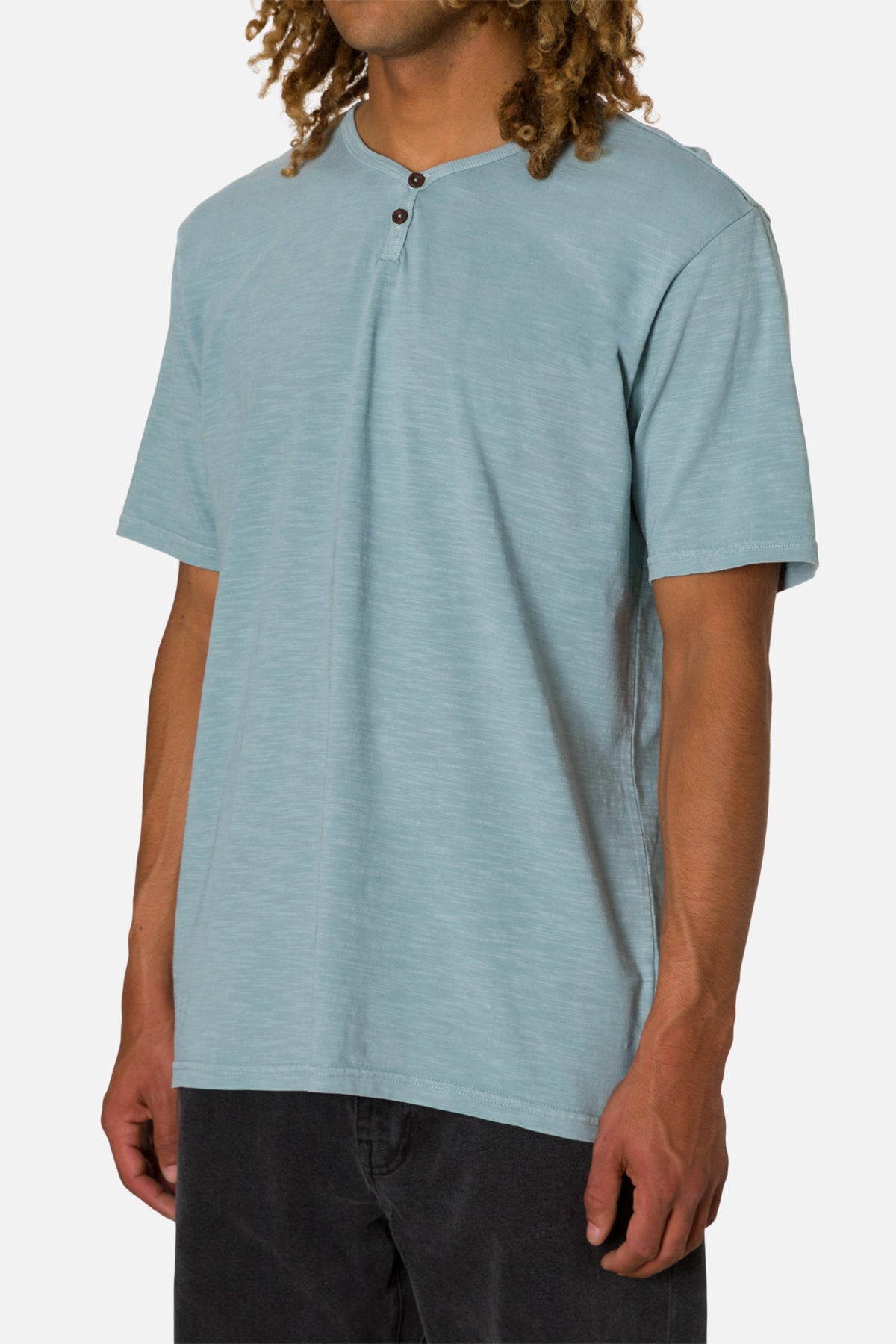 Person wearing a light blue henley shirt on a white background