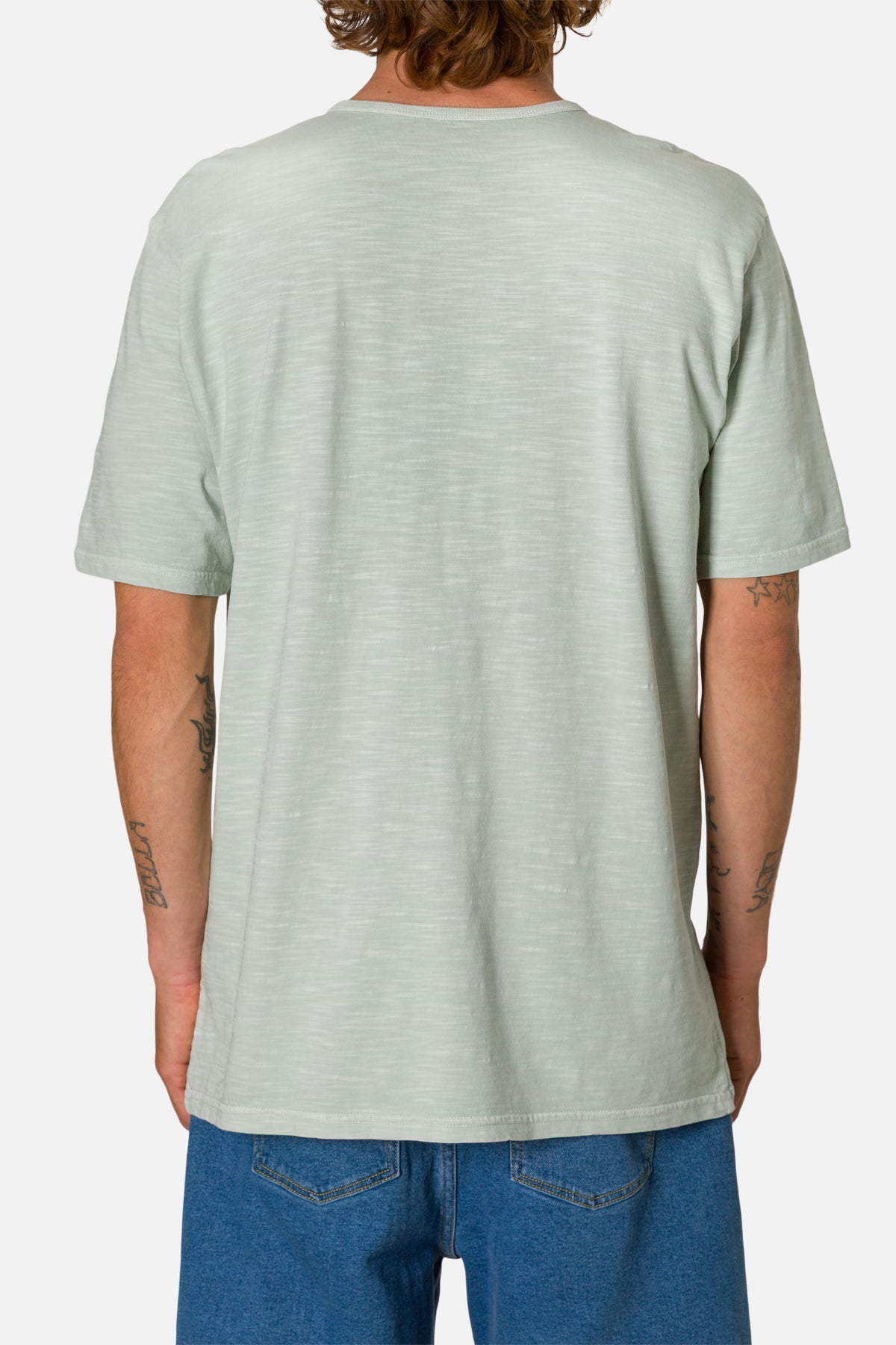 Person wearing a light green henley shirt on a white background