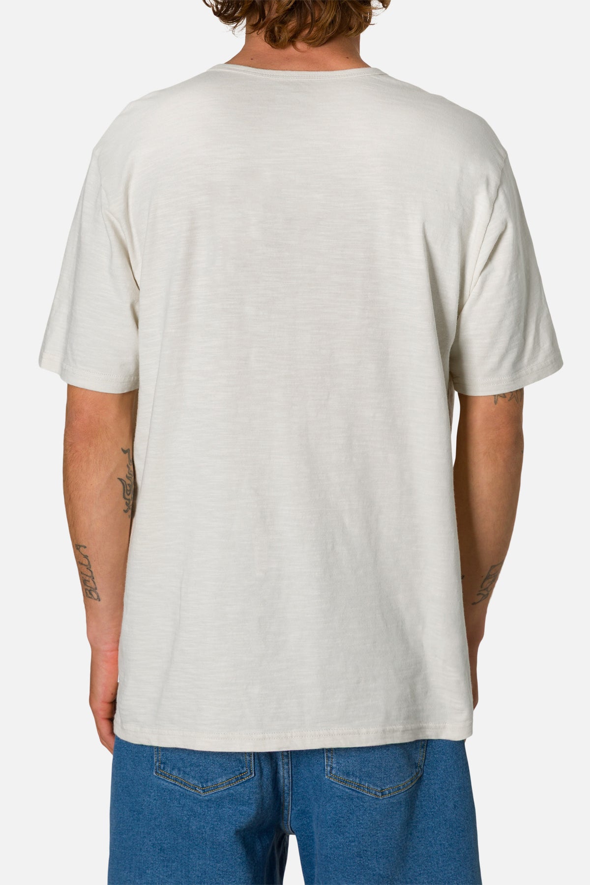 Person wearing a white henley shirt and blue jeans on a white background