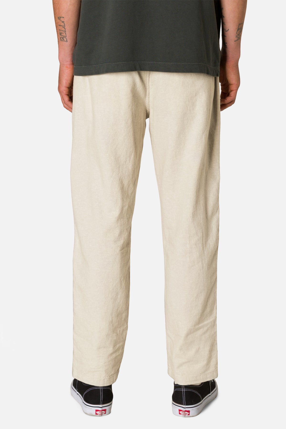 Beige pants worn by a person on a white background