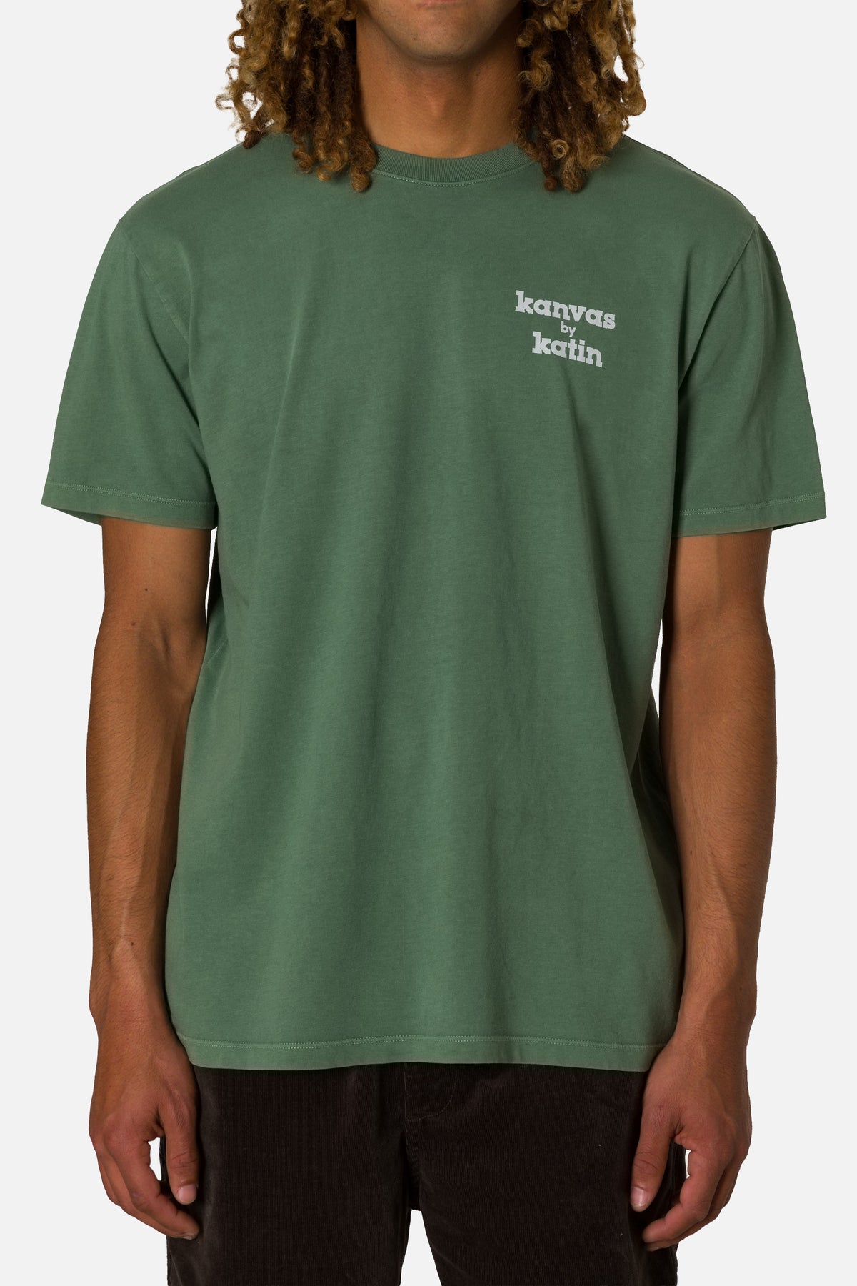 Person wearing a green t-shirt with text on a plain background