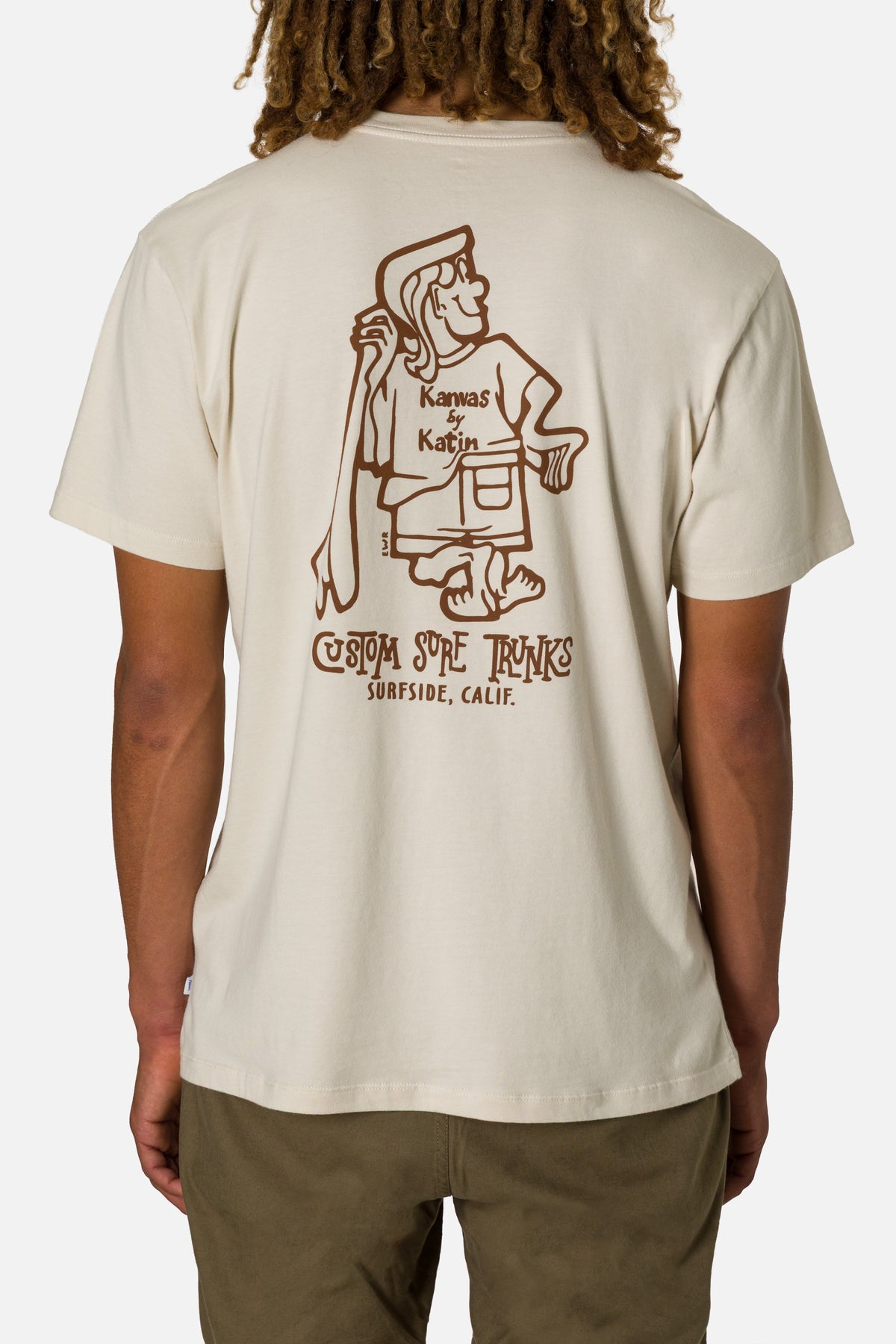 Person wearing a beige t-shirt with a graphic design on the back, standing against a plain background.