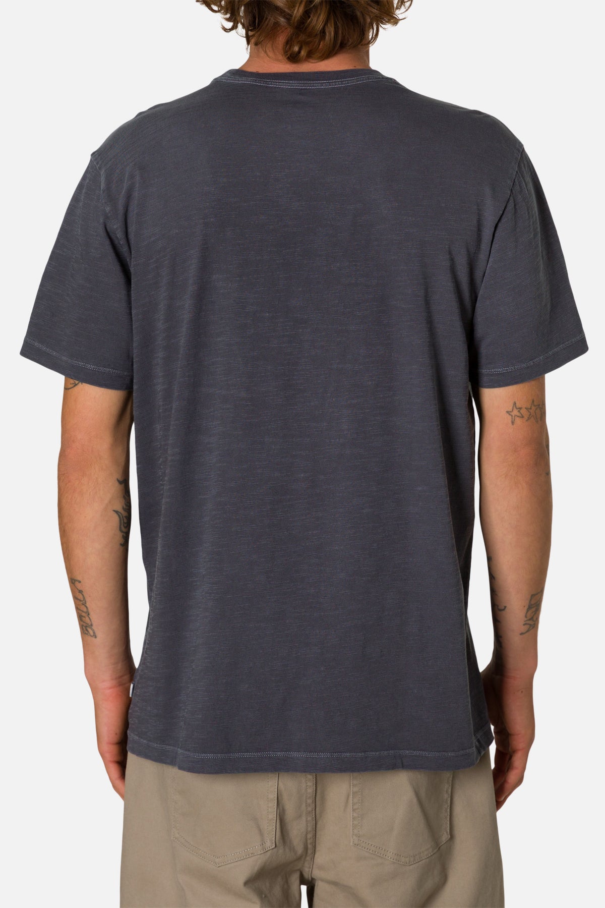 Back view of a person wearing a plain dark gray t-shirt on a white background