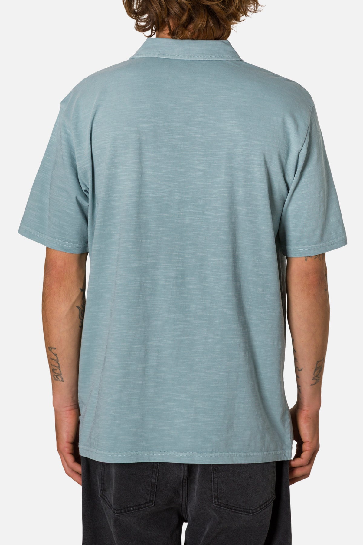 Person wearing a light blue polo shirt on a white background