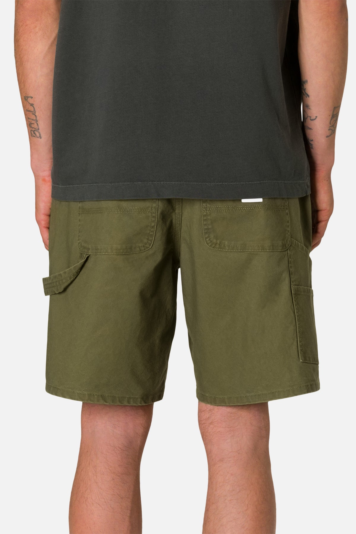 Back view person wearing Olive shorts and a black shirt on a plain background