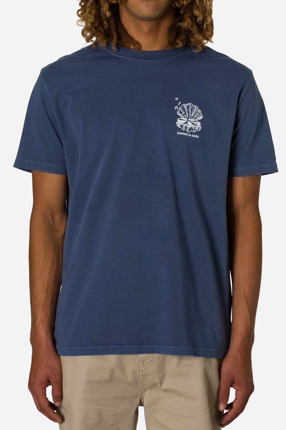 Person wearing a blue t-shirt with a logo on a white background