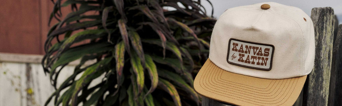Field Hat in Vintage White/Ermine with a Kanvas by Katin patch on a weathered fence